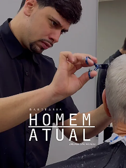 Barbeiro acertando o corte de um cliente grisalho