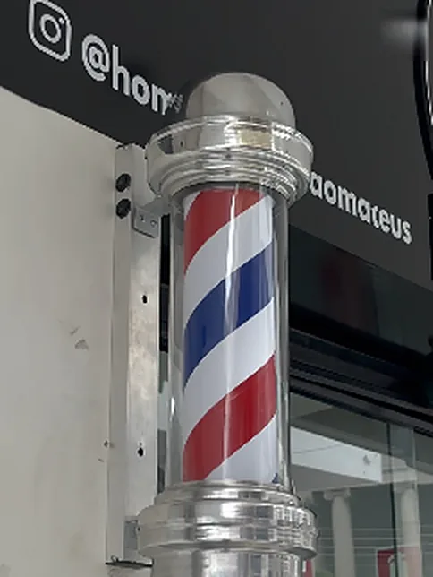 Poste de barbearia listrado na entrada da unidade